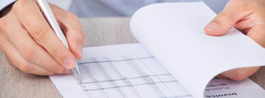 picture of mans hands working on invoices 